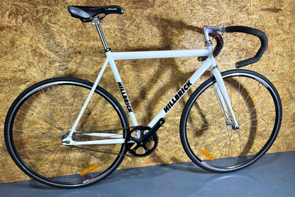 White bicycle with black components against a wooden background