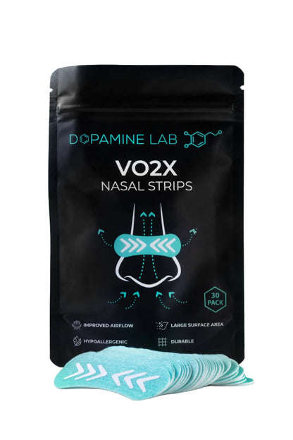 A black stand-up pouch labeled 'Dopamine Lab VO2X Nasal Strips' with a stack of light blue nasal strips placed in front on a reflective white surface against a dark gray background.