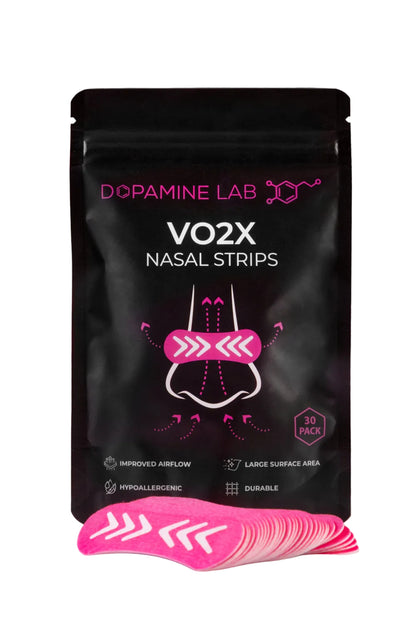 A black stand-up pouch of Dopamine Lab VO2X Nasal Strips with a fan of bright pink nasal strips placed in front on a reflective white surface against a dark gray background.